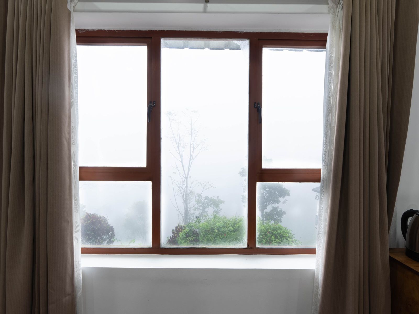Misty hills through the Premium Room window at Zen Garden Vagamon