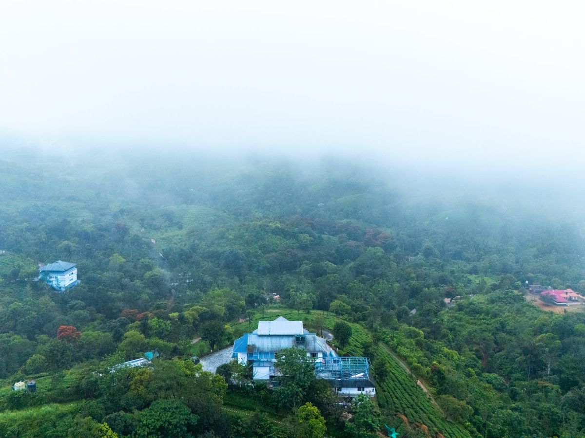 Morning mist drifting over the forested hills around Zen Garden Vagamon